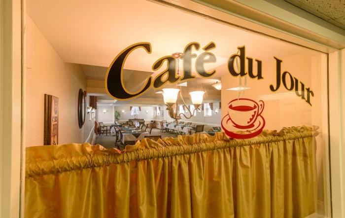 The interior of Caf du Jardin, showcasing its cozy ambiance and decorative sign.