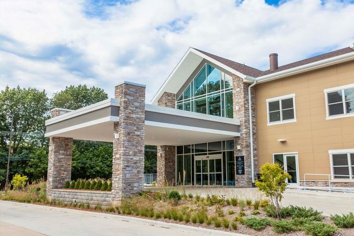 A modern building entrance with large glass windows and stone accents.
