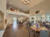 A spacious and modern living room with an open design, featuring a chandelier, dining area, and contemporary furniture.