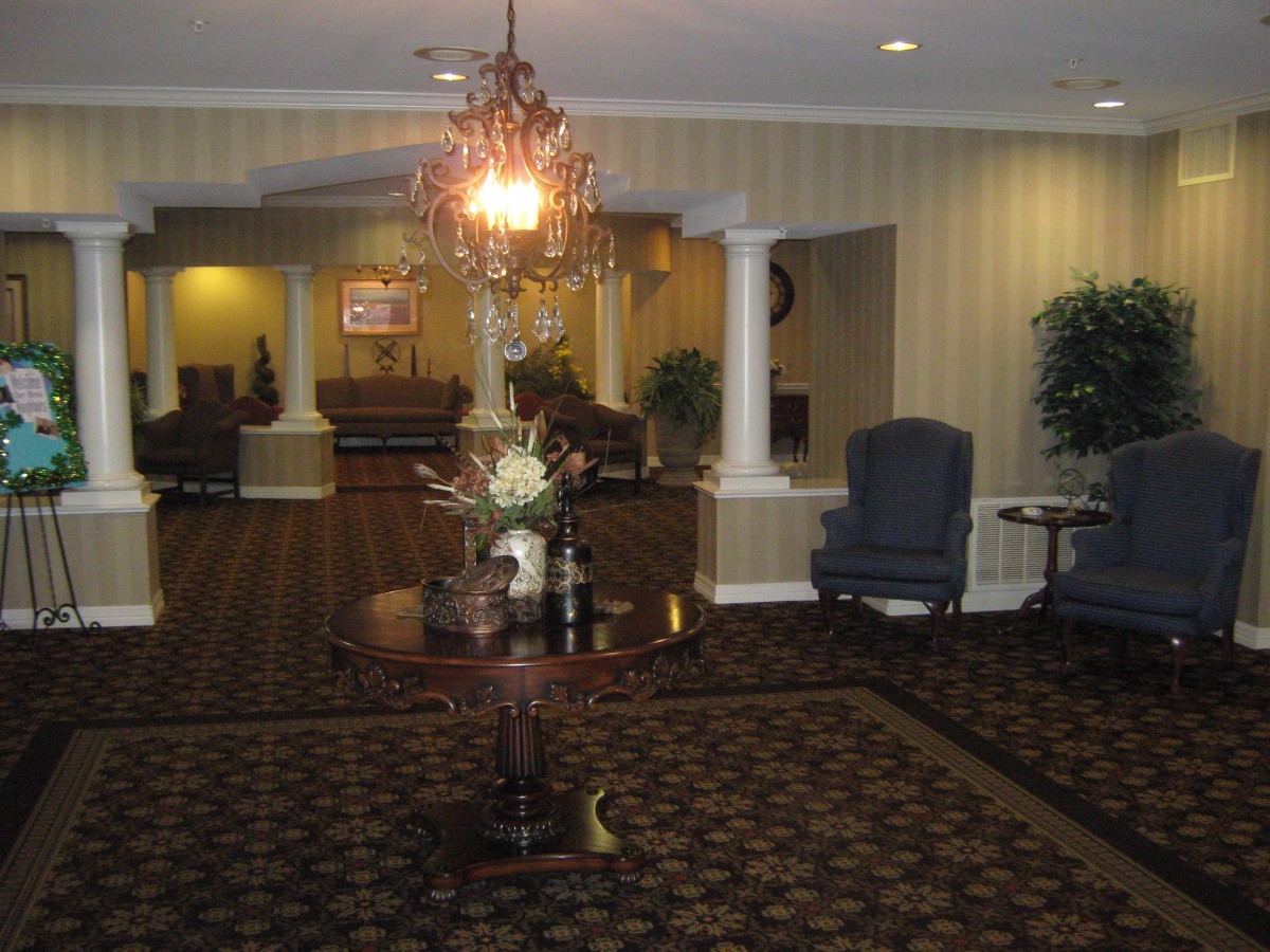 An elegant hotel lobby featuring a chandelier and classic furniture.