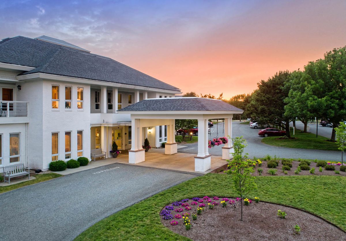 A beautiful building entrance with a landscaped garden at sunset.