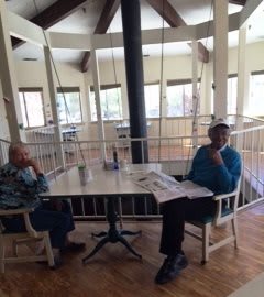 Two individuals seated at a table in a well-lit indoor space.