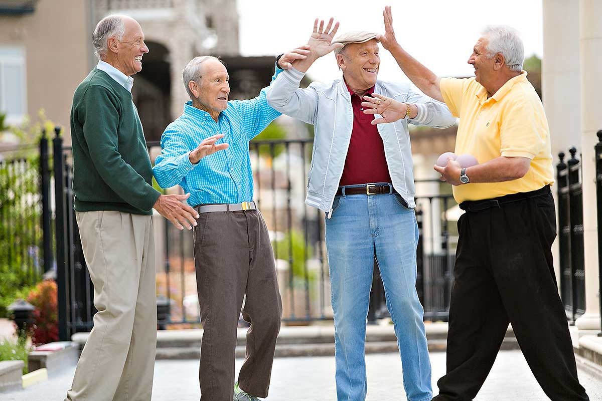 A group of elderly men enjoying each other's company outdoors.