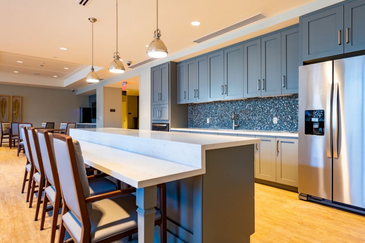 A modern kitchen with an island and pendant lighting.