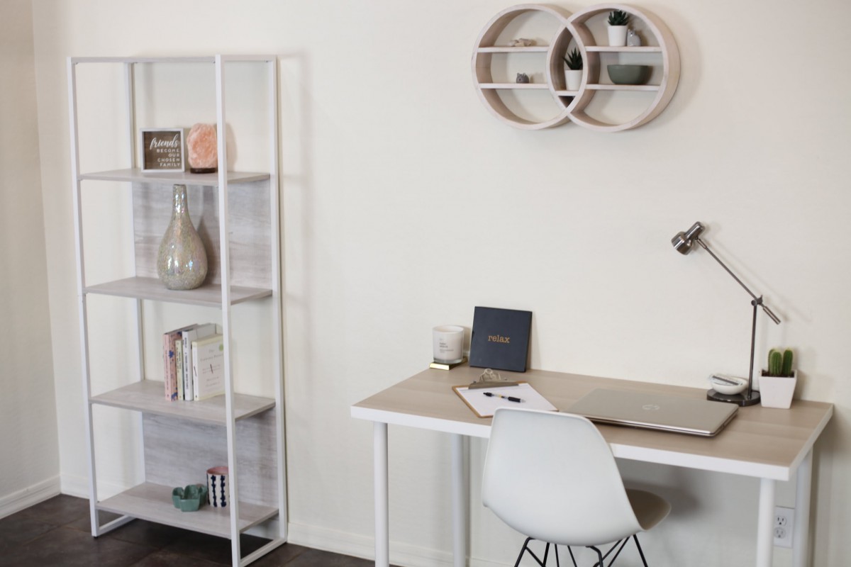 A minimalist home office setup with a modern desk and shelving.