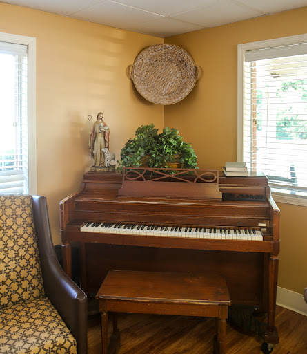 A cozy corner featuring a piano and comfortable seating, adorned with decorative elements.