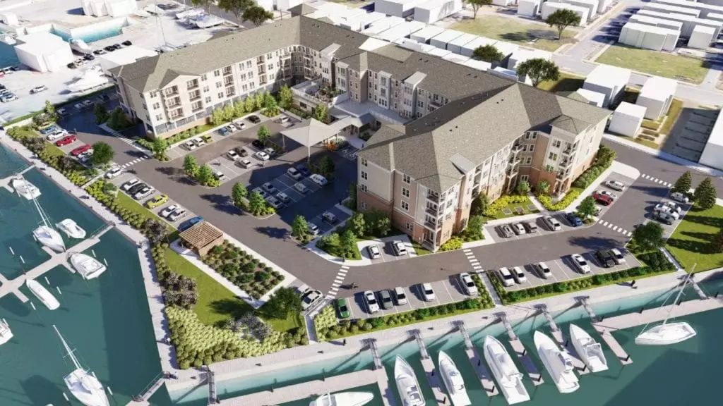 Aerial view of a residential complex with a marina and parking facilities.