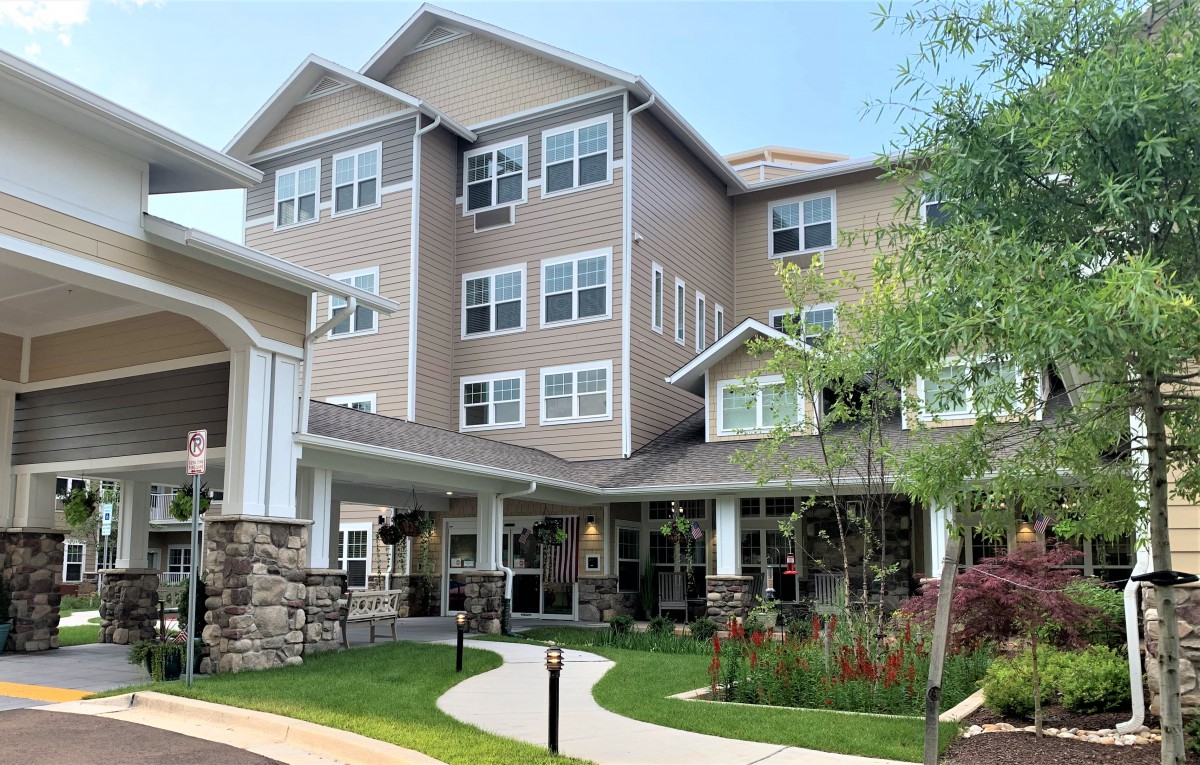 A modern multi-story residential building with well-maintained landscaping.