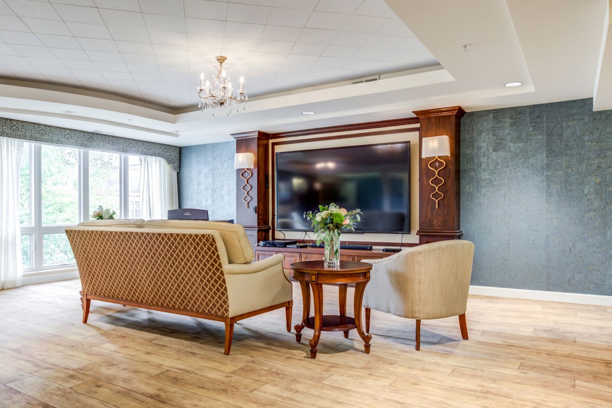 A luxurious living room with elegant furnishings and a large television.