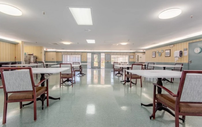 An empty dining room with several tables and chairs arranged neatly.