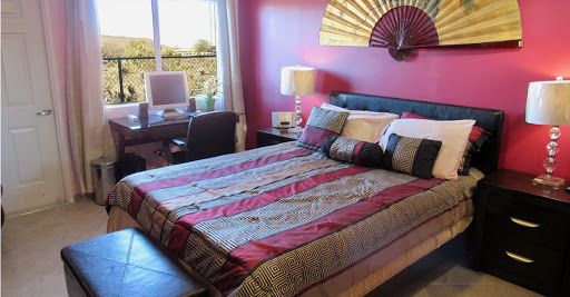 A cozy bedroom featuring a colorful bedspread and modern decor.