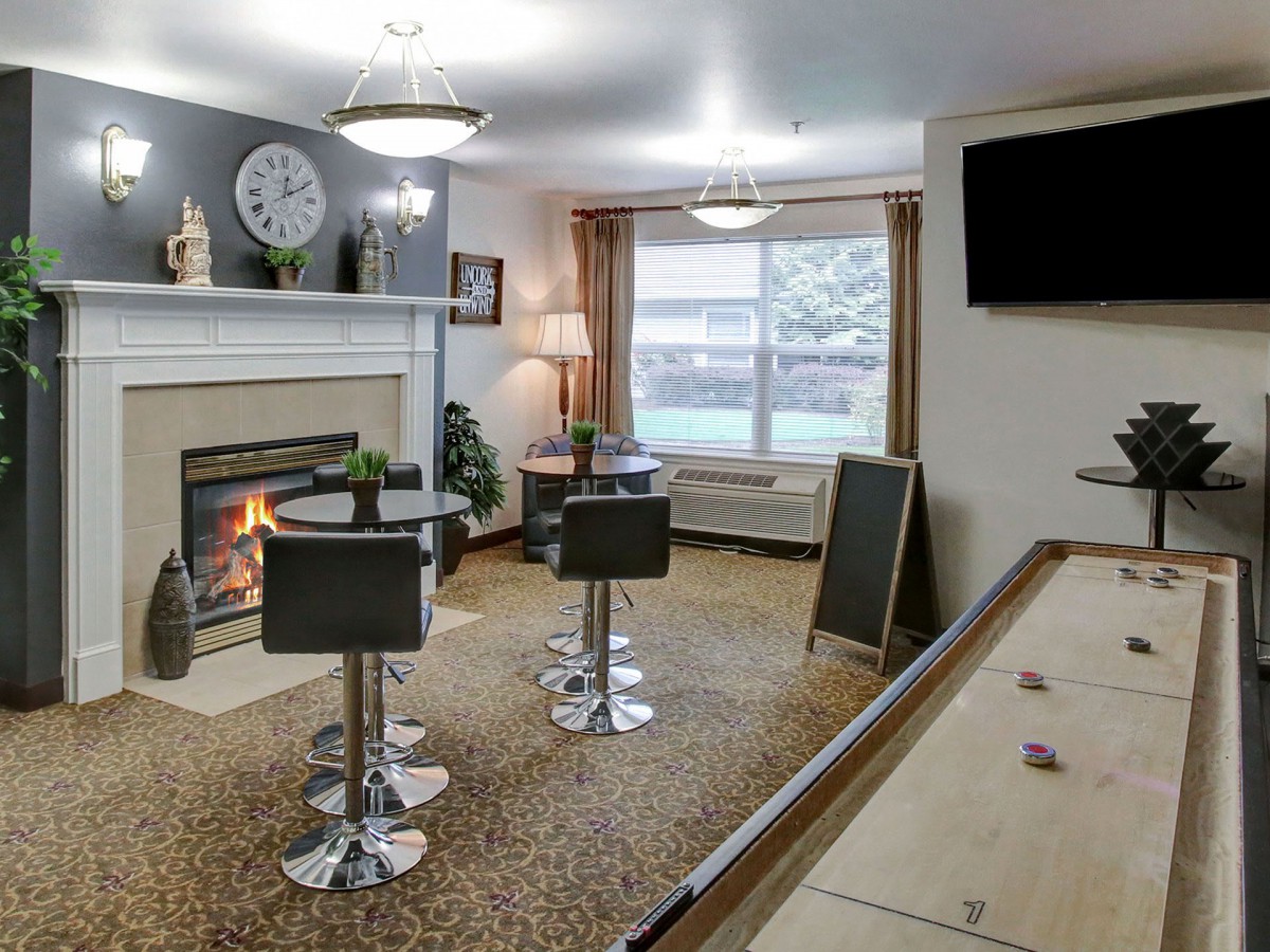 A cozy living room with modern seating, a fireplace, and a wall-mounted TV.
