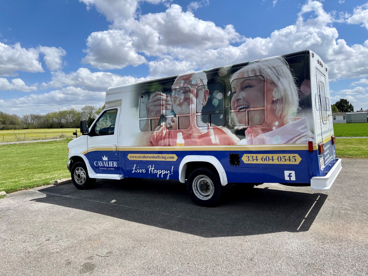 A van with an advertisement for home healthcare services parked outdoors under a cloudy sky.