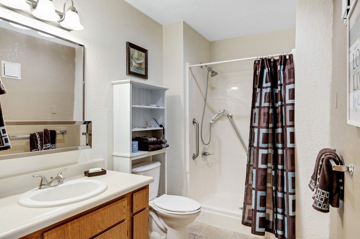 A neatly arranged bathroom with a shower, sink, and toilet.
