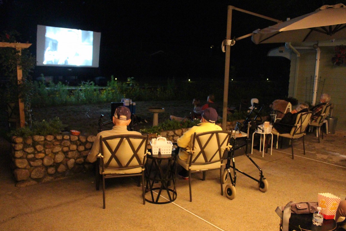 People enjoying an outdoor movie screening at night.