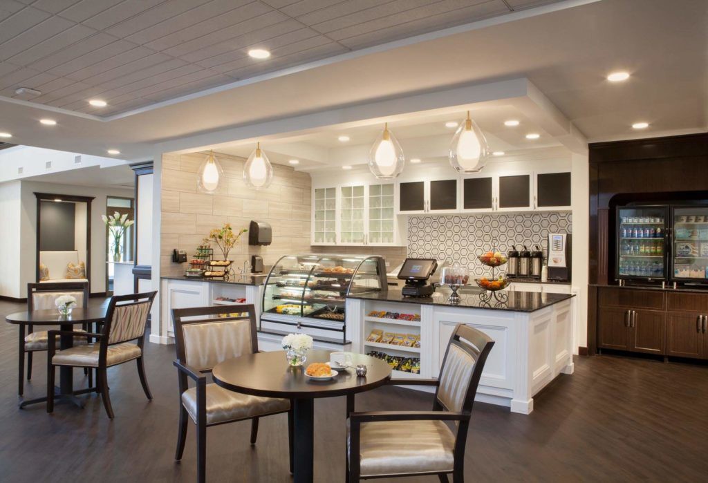 A modern cafe interior with stylish seating and a well-lit counter area.