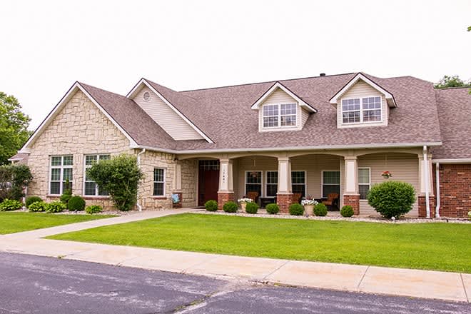 A suburban house with a neatly maintained lawn and a brick exterior.