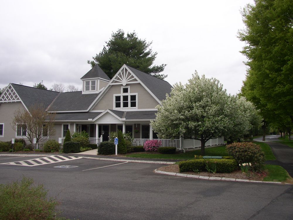 A charming residential building with a neatly landscaped yard and driveway.