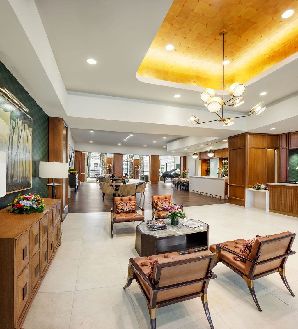 A modern lobby interior featuring stylish furniture, elegant chandeliers, and a welcoming reception area.