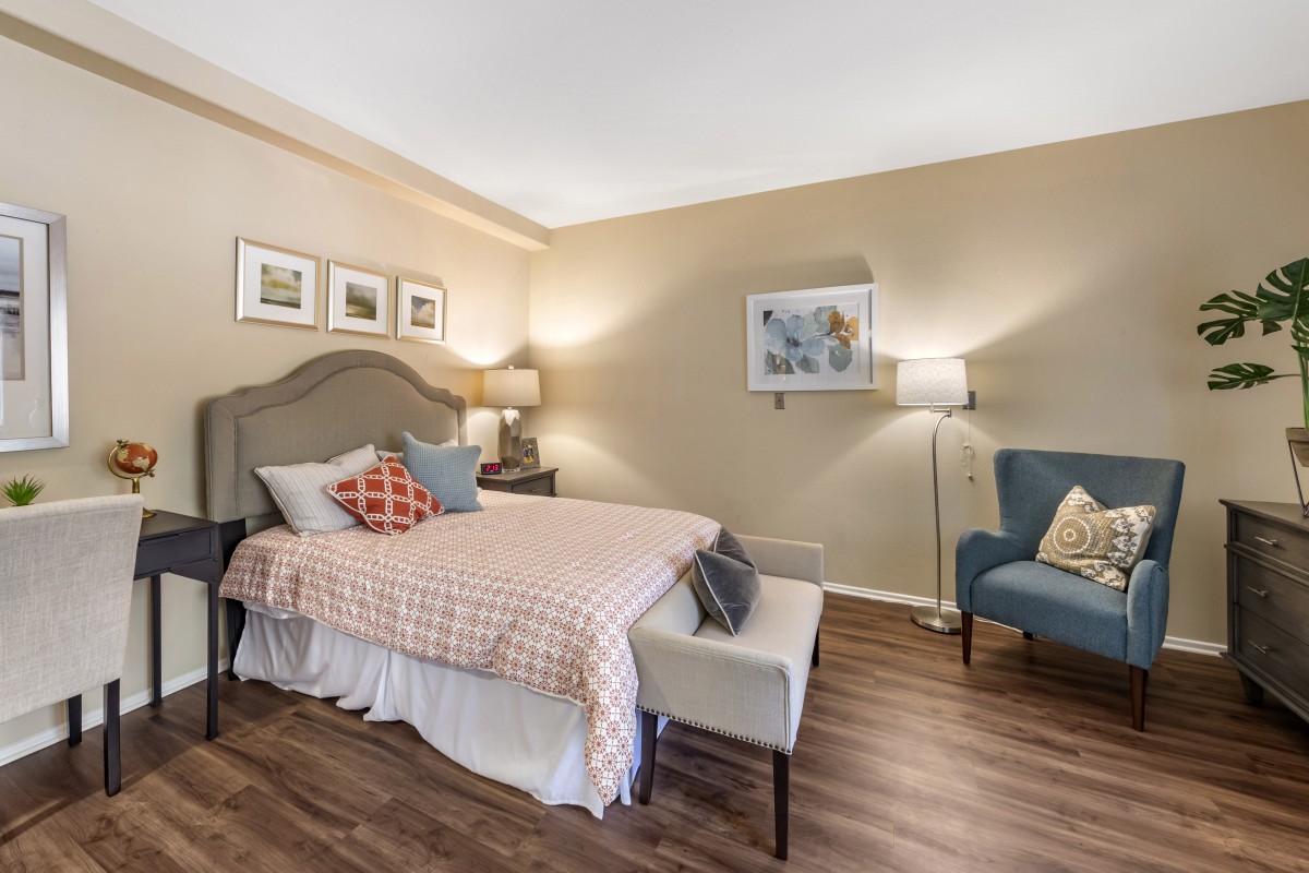 A cozy bedroom featuring a comfortable bed, stylish furniture, and warm lighting.