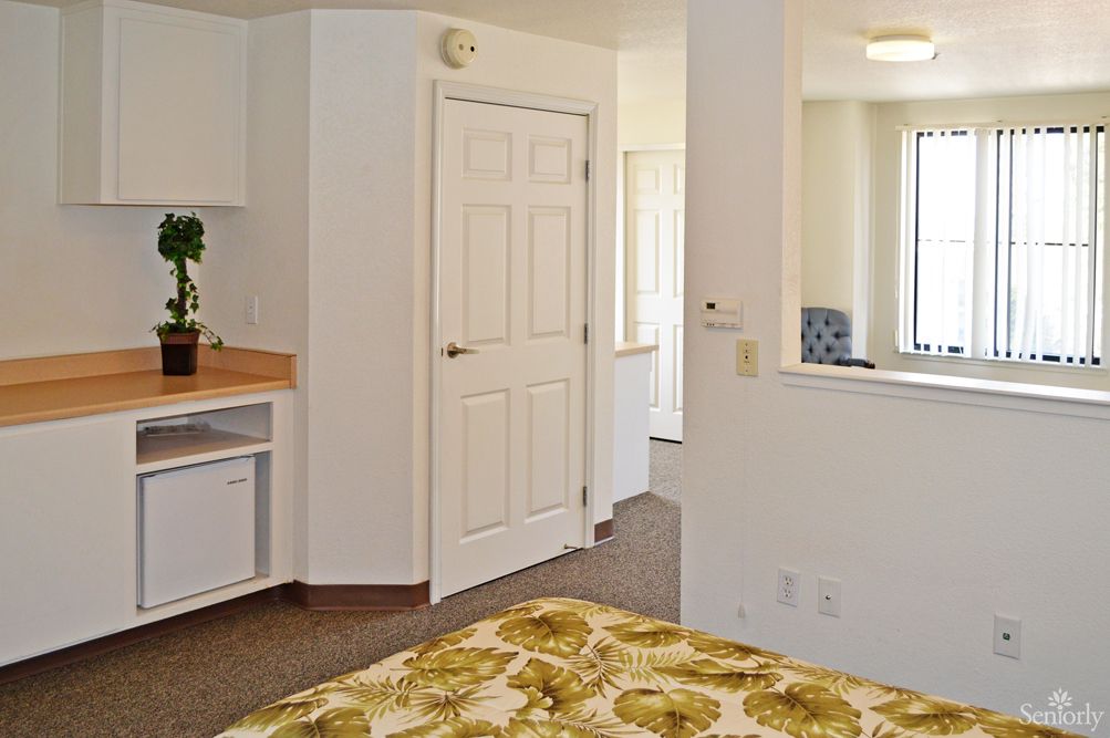 A minimalist bedroom interior with a focus on natural light and neutral decor.
