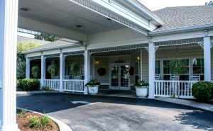Entrance of a building with a covered porch and decorative columns.