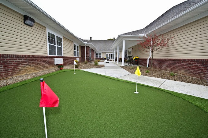 A residential courtyard featuring a putting green with colored flags.