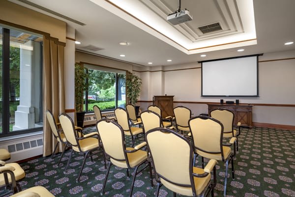A small conference room set up for a meeting with chairs facing a projector screen.