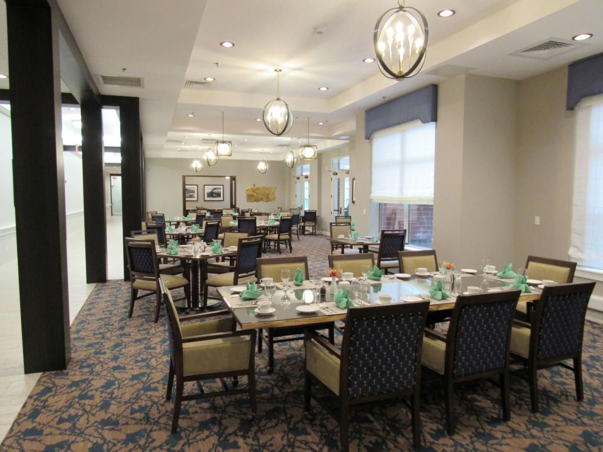 A well-lit dining room with neatly arranged tables and chairs.