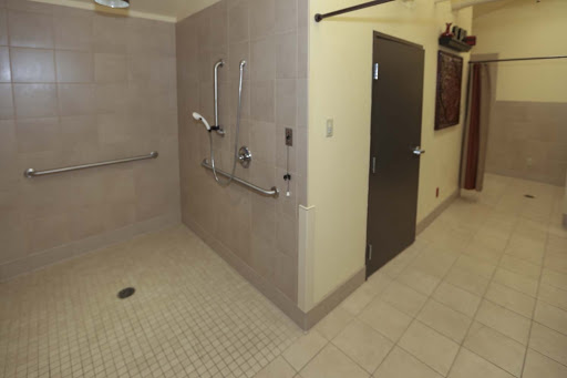 An accessible bathroom featuring a spacious shower area with grab bars.
