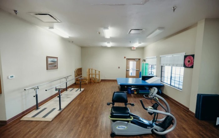 A rehabilitation room equipped with exercise machines and therapy tools.
