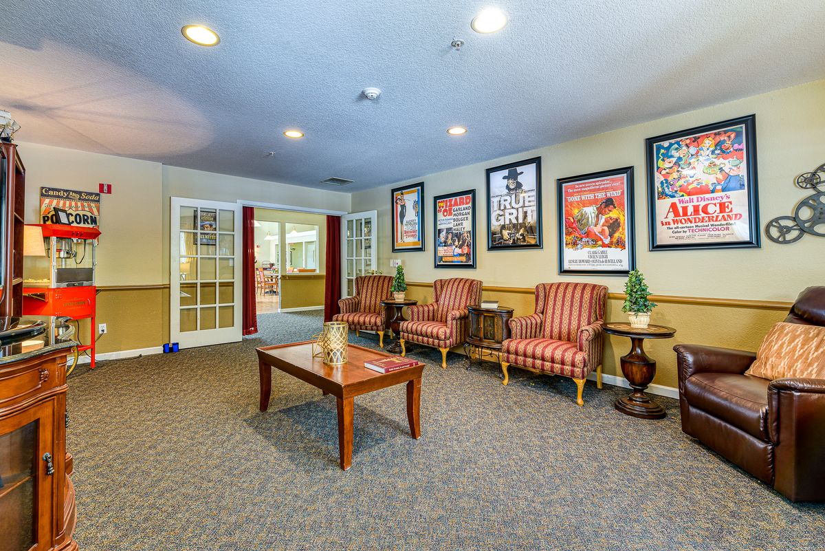A cozy waiting area with comfortable chairs, a wooden table, and colorful posters on the walls.
