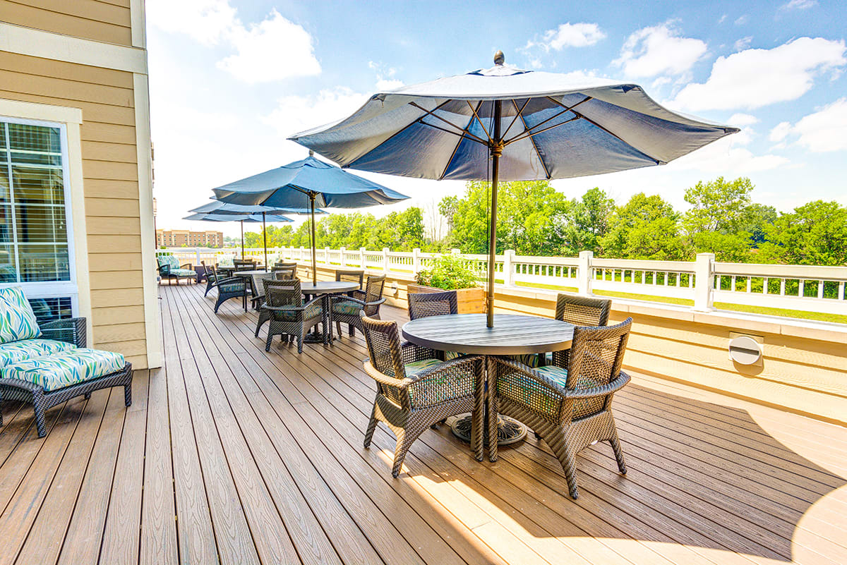 Outdoor patio with tables, chairs, and umbrellas on a sunny day.