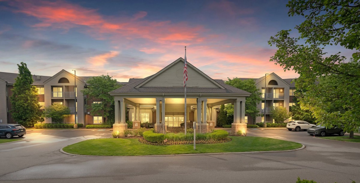 A well-lit building entrance with columns at sunset.