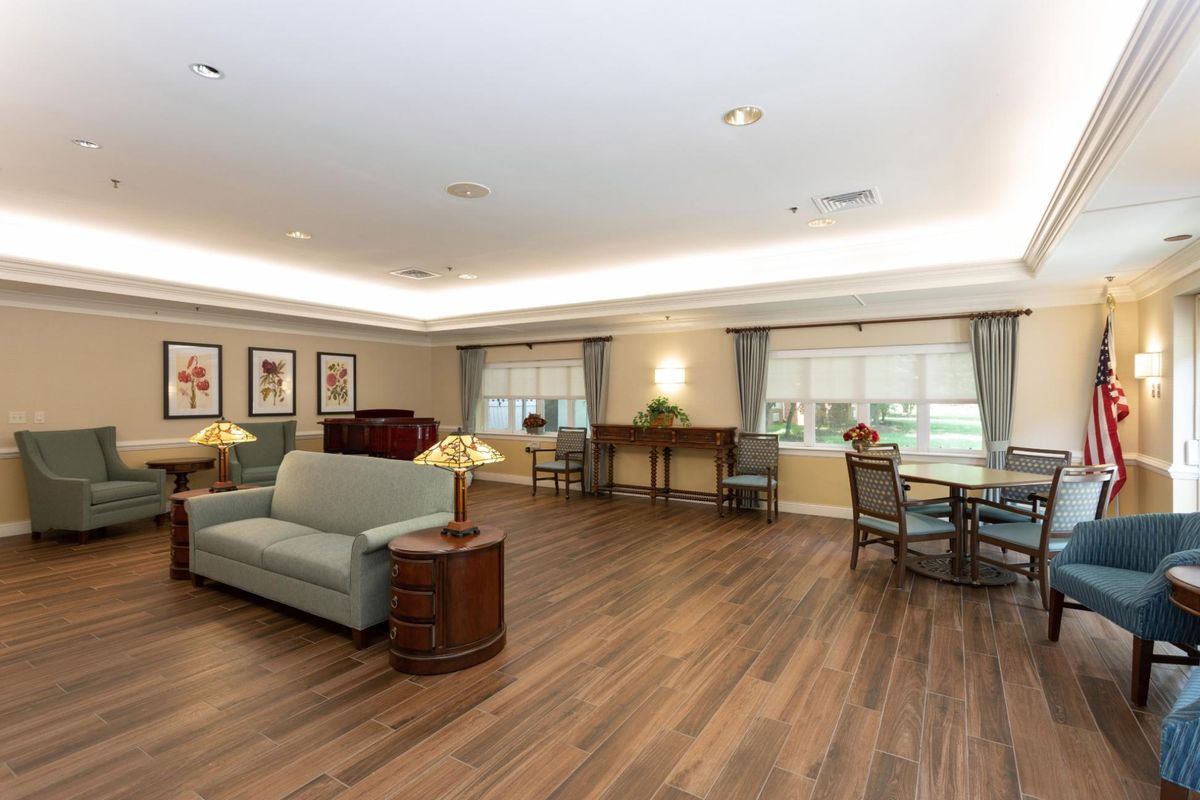 A spacious living room with wooden flooring, comfortable sofas, and elegant decor.