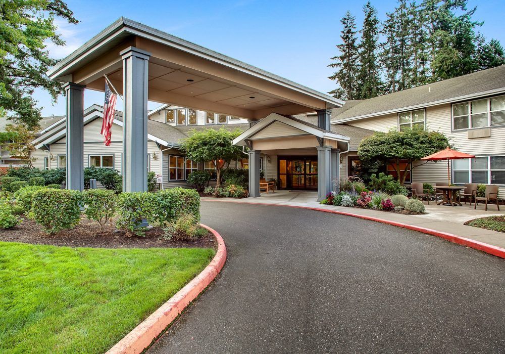 A welcoming building entrance with a covered driveway and well-maintained landscaping.