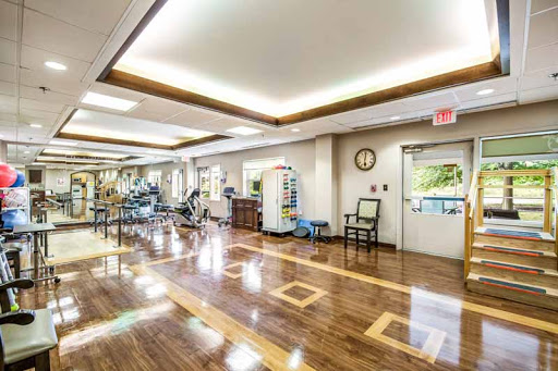 A spacious rehabilitation center equipped with exercise machines and well-lit areas for patient activities.