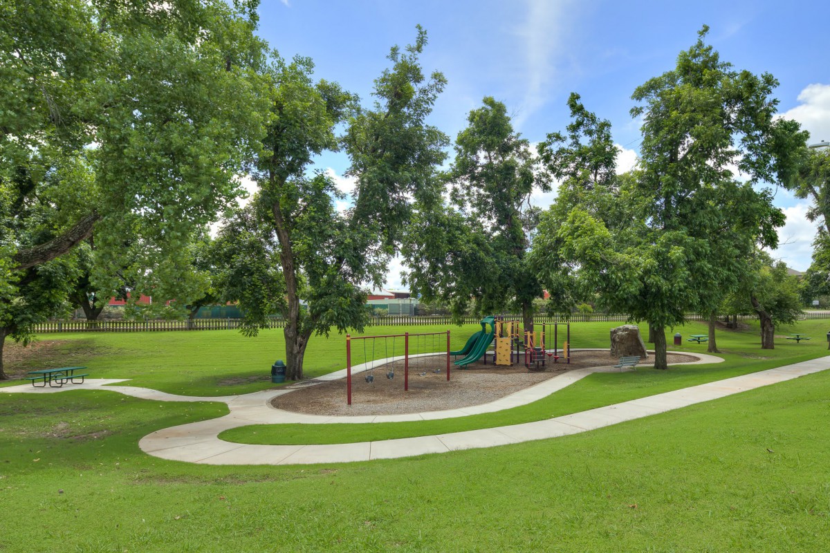 A scenic view of a playground surrounded by lush greenery and winding pathways.