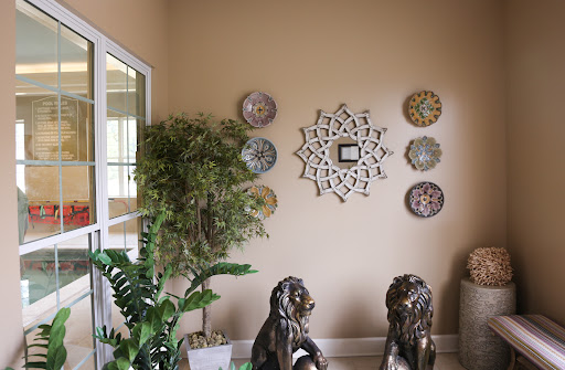 A cozy corner of a living room featuring lion statues, decorative wall plates, and a lush plant.