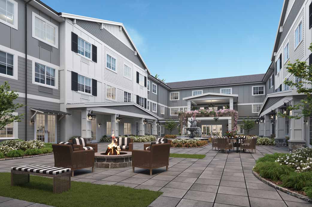 A modern residential building with a well-furnished courtyard featuring outdoor seating.