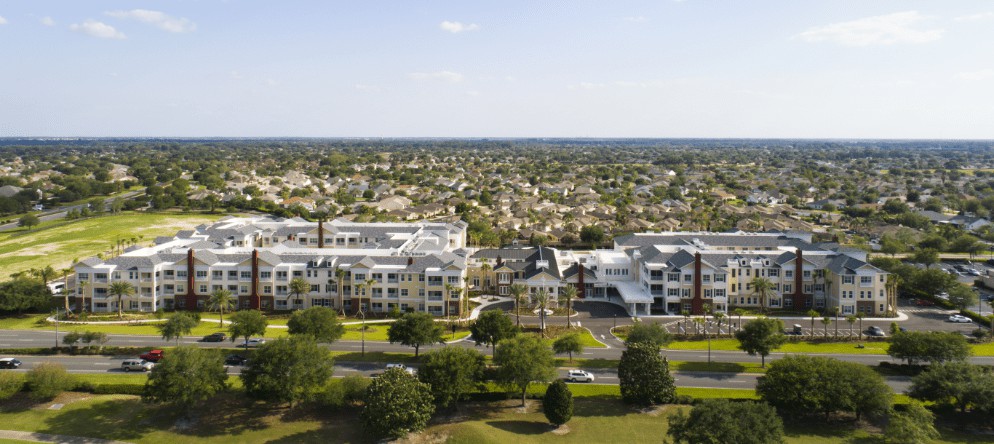 An aerial view of a residential area with modern buildings and a park.