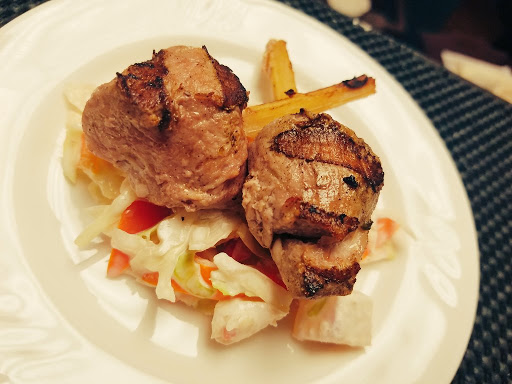A delicious serving of grilled meat accompanied by a fresh salad.
