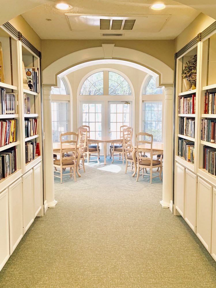 A cozy reading area with bookshelves and large arched windows letting in natural light.