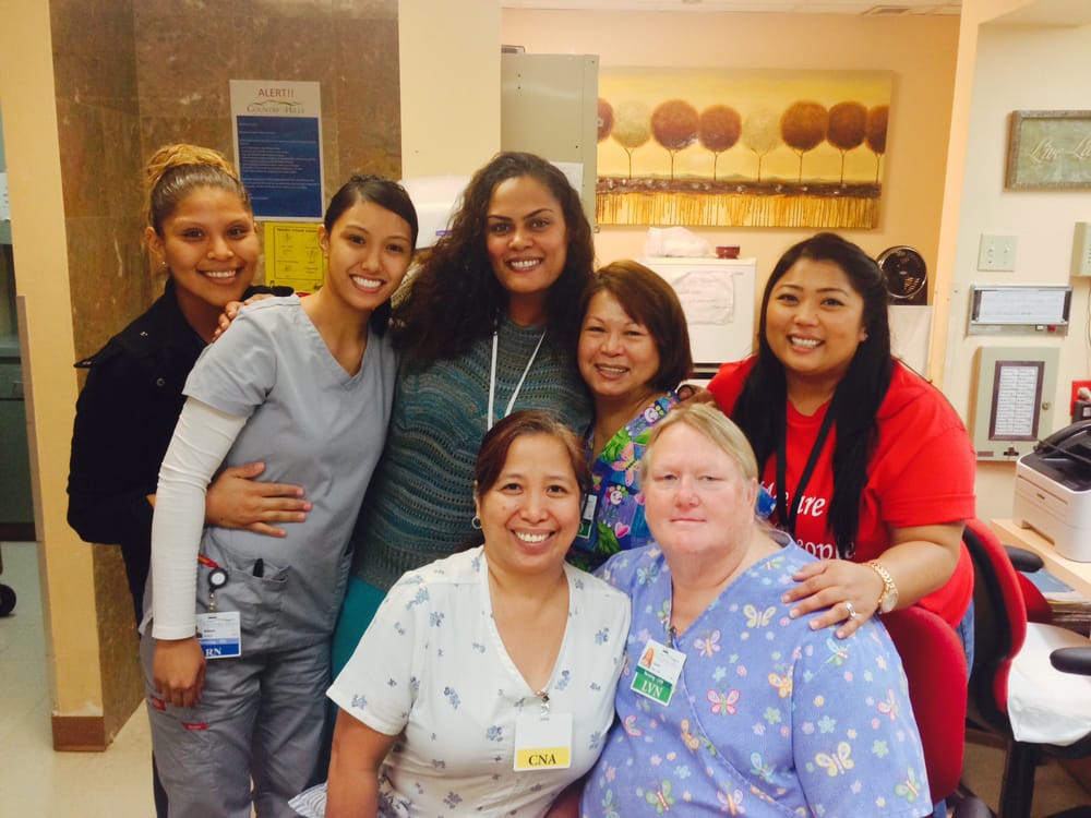A cheerful group of healthcare professionals posing together in a hospital setting.
