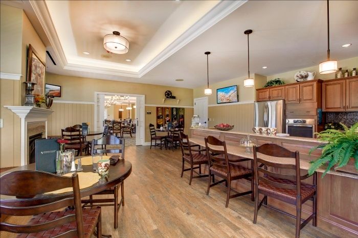 A modern kitchen and dining area with a bar counter and pendant lighting.