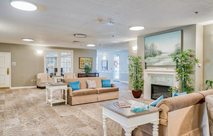 A cozy and modern living room featuring comfortable sofas, a stylish coffee table, and a fireplace adorned with artwork.