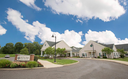 A serene view of a building with a clear blue sky and fluffy clouds.