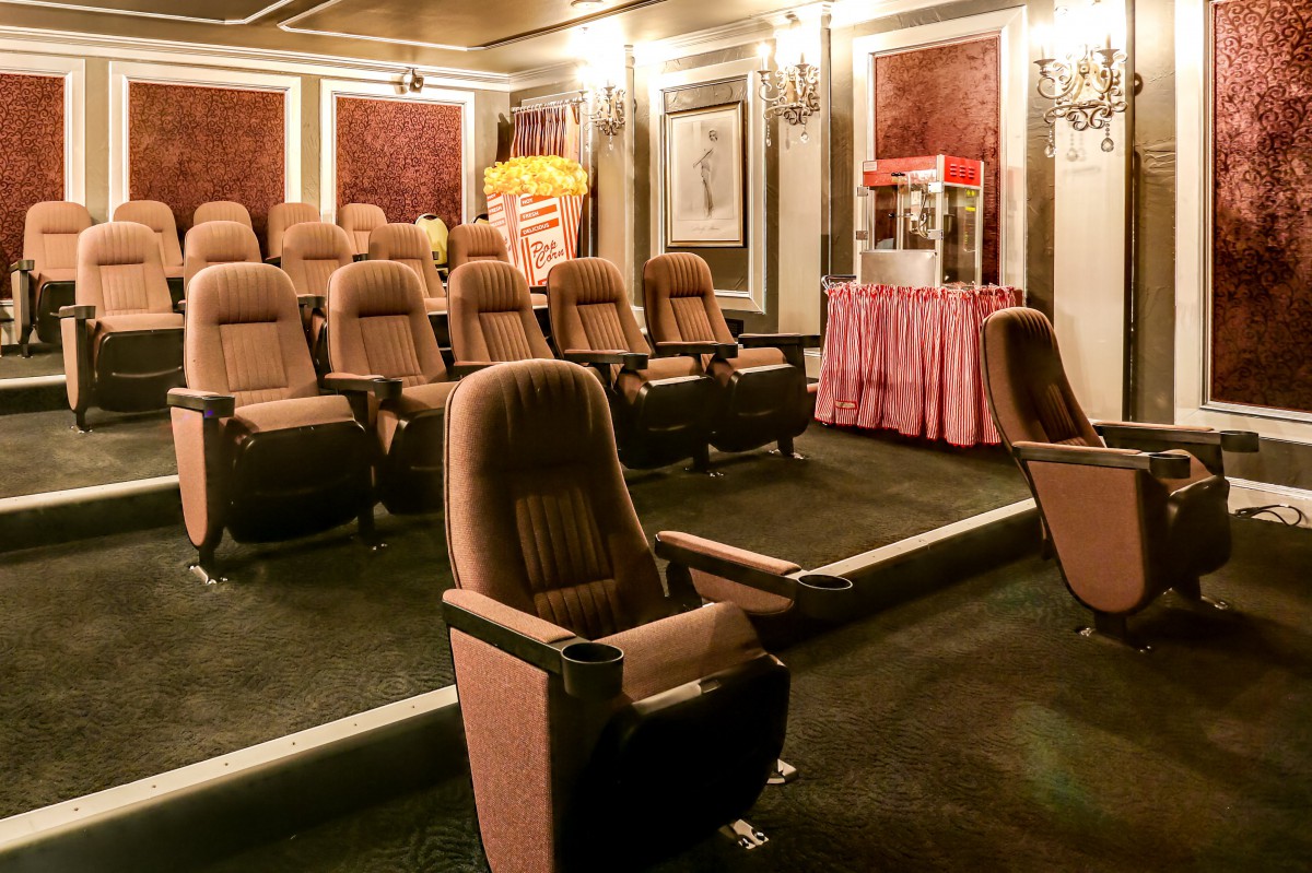 A cozy home theater with comfortable seating and a popcorn machine in the corner.