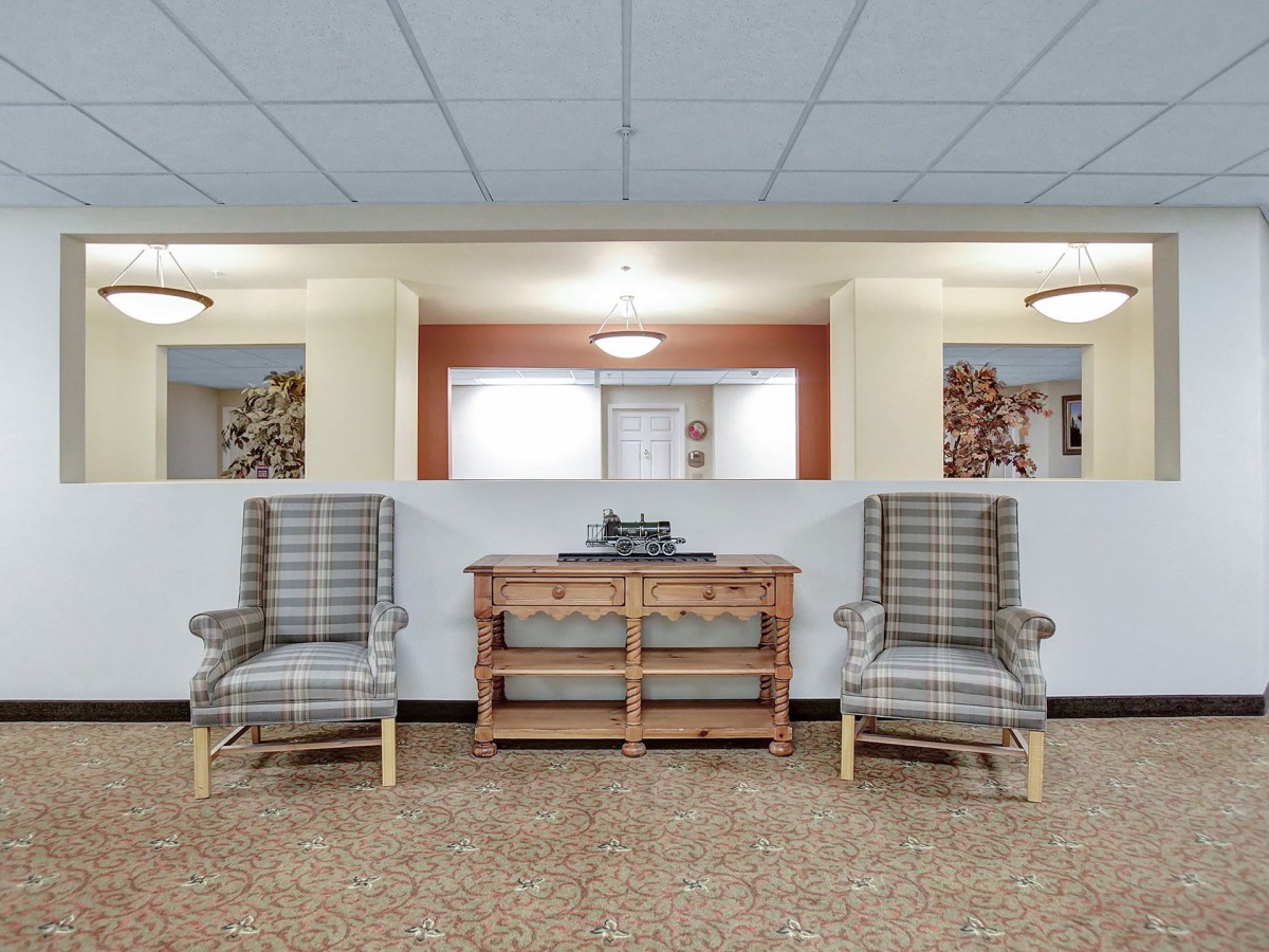 A cozy seating area with plaid armchairs and a wooden console table.