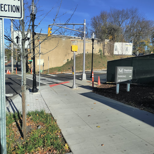 A view of a quiet street intersection with traffic signals and a clear blue sky.